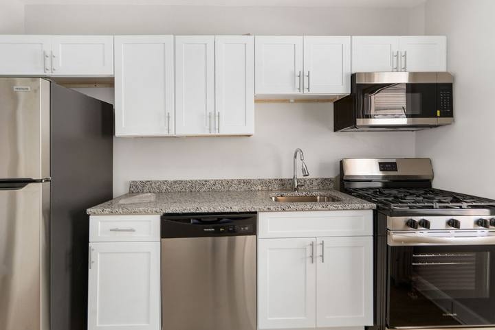 Kitchen with a stainless refrigerator, gas range and granite counters