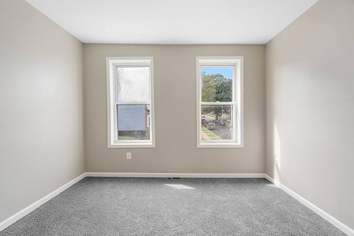 Carpeted bedroom with two windows looking out over the street